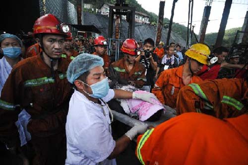 Rescuers carry a miner onto an emergency car at the Qielichong colliery in Sandu Township of Leiyang, central China's Hunan Province, July 8, 2012.[Xinhua]