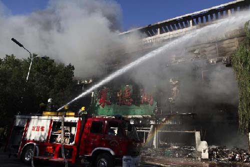 Firefighters spray water to put out a fire in Tianjin, North China, June 30, 2012. A fire broke out at a shopping mall in Tianjin's Jixian County on June 30. Photo: Xinhua 