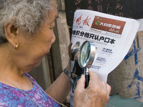 A senior resident reads a newspaper in Zhenjiang, Jiangsu province, on Friday. Feng Bo / for China Daily