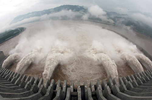 Water cascades from six sluices at Three Gorges Dam on Friday after a flood with a peak flow of 55,500 cubic meters per second on Thursday night significantly raised the water level in the dam's reservoir. Zhai Pingguo / for China Daily