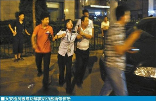 A female security inspector is rescued after being taken hostage of by a man at a subway station in Beijing on Thursday night. [Xinhua]