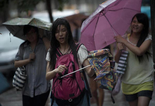 Citizens walk against the rainstorm in a street of Wanchai, south China's Hong Kong, July 23, 2012. Hong Kong Observatory forecasted typhoon Vicente would pass the area of about 150 kilometers southweat away from Hong Kong during Monday night and Tuesday morning. (Xinhua/Lui Siu Wai)