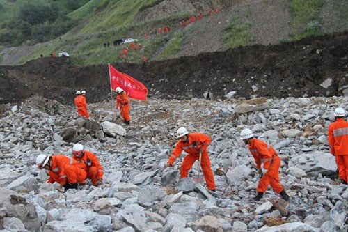 Rescue workers search for victims after a mudslide hit Northwest China's Xinjiang Uygur autonomous region Tuesday morning. [Photo/Xinhua]