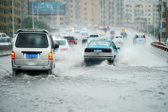 Vehicles move in rain on a flooded overpass in Harbin, capital of northeast China's Heilongjiang Province, July 29, 2012. (Photo: Xinhua)