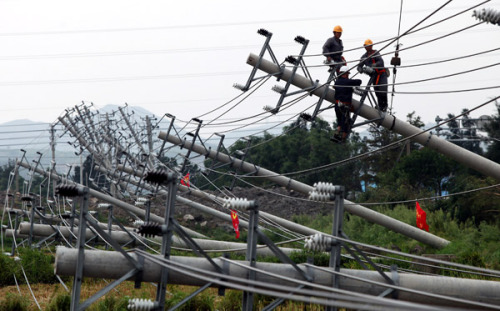 Cable workers make an urgent repair on transmission lines damaged by heavy rain and strong wind brought by Typhoon Haikui on a provincial highway of Songmen Twonship in Wenling City, east China's Zhejiang Province, Aug. 8, 2012.