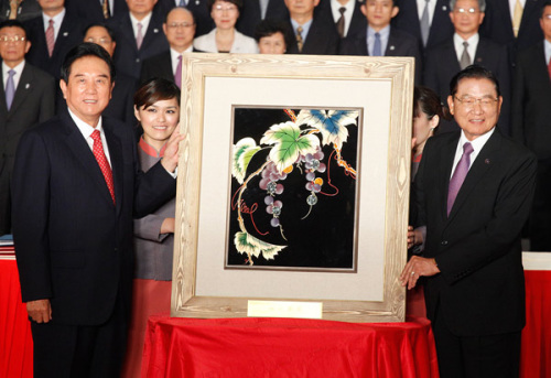 Chiang Pin-kung (right), chairman of Taiwan's Straits Exchange Foundation, presents a lacquer painting to Chen Yunlin, president of the mainland's Association for Relations Across the Taiwan Straits, in Taipei on Thursday after they signed two agreements to boost investment and customs cooperation across the Straits.