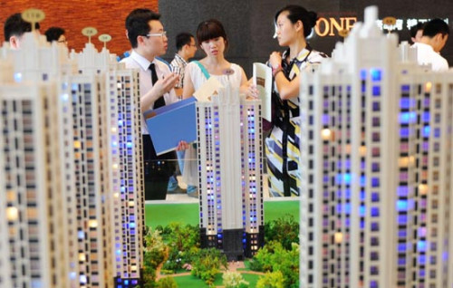 A salesman talks with potential homebuyers at a real estate fair in Qingdao, Shandong province. With the government making an effort to rein in the once-overheated property market, growth in investment in real estate development in the country slowed down