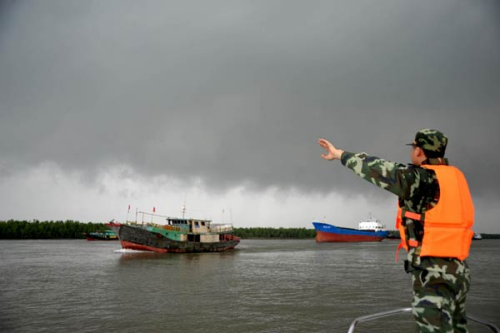 A border policeman directs a ship before the approaching typhoon Kai-Tak in Zhongshan, South China's Guangdong province, Aug 16, 2012. [Photo/Xinhua] 