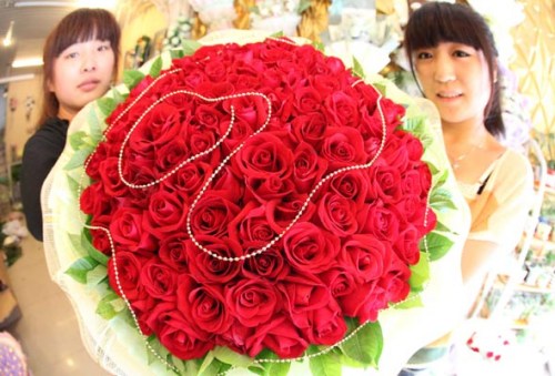 Two girls display Valentine's Day bouquets at a florist on August 19, Bozhou city, Anhui province. [Liu Qinli/Asianewsphoto] 