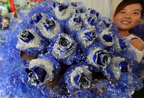 A girl displays Valentine's Day bouquets at Xingfuqiao Flower Market on August 20, Bozhou city, Anhui province. [Zhang Yanlin/Asianewsphoto]