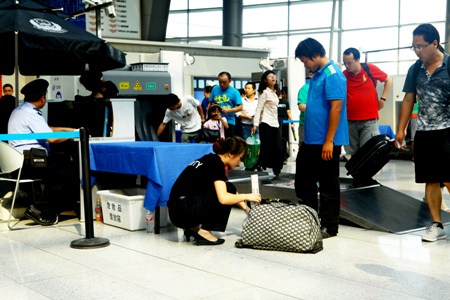 Security check staff at the Beijing South Railway Station inspect a passenger's bag Thursday. Security has been stepped up in the city ahead of the 18th National Congress of the CPC. Photo: Guo Yingguang/GT 