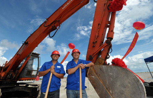 Workers relax briefly at the commencement ceremony of the sewage treatment plant in Yongxing Island on Saturday. [Photo/Xinhua]