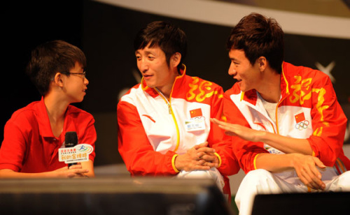 Zou Shiming (center), a champion boxer at the London Games, and Chen Ding, gold medalist in the men's 20-km walk, talk about their experience with a student at an event in Hong Kong's Queen Elizabeth Stadium on Sunday. [Photo/Xinhua]