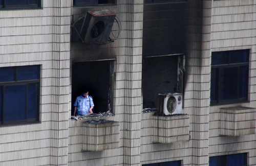 A police officer investigates the scene of an arson that killed three people on Monday in Shaoyang, Hunan province. Guo Guoquan / for China Daily