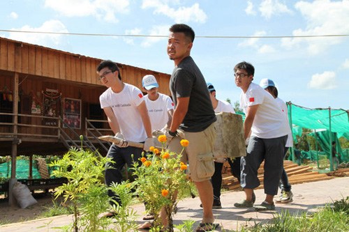 Xu Jiatian and other volunteers help build wooden classrooms and dormitories for children in Siem Reap, Cambodia. [China Daily]