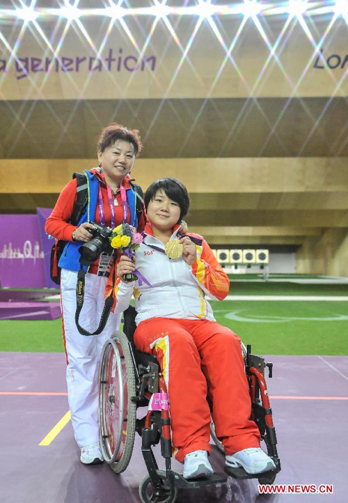 Zhang Cuiping (R) of China poses with her coach Wang Ping after the awarding ceremony for the final of the Women's R2-10m Air Rifle Standing-SH1 shooting event at London 2012 Paralympic Games in London, Britain, on Aug. 30, 2012. Zhang took the gold medal