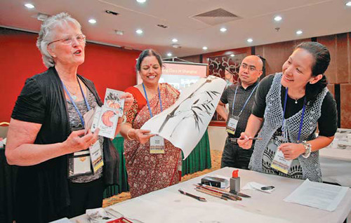 Barbara Bornet Stumph, left, a teacher from the US, highlights the appeal of Chinese painting at a workshop during a conference of the East-West Center in Beijing on Sunday. Photo by Kuang Linhua / China Daily 