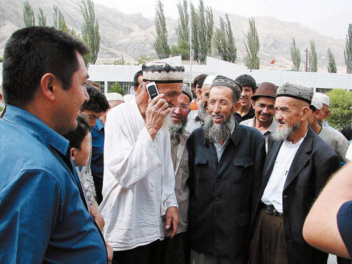 An elderly Uygur villager trying his new cellphone by calling his relatives. Xinjiang Uygur autonomous region is experiencing rapid change thanks to the introduction of mobile technology. China Mobile Ltd, the nation's biggest mobile operator by user base