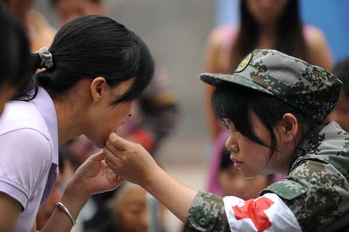 An armed police medic examines a patient who was injured in Fridays earthquake in Yiliang county, Yunnan province, on Sunday. Wei Xiaohao / China Daily 