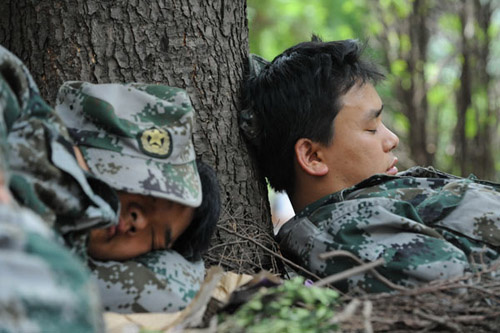 Fatigued rescuers nap on the ground in Yiliang, Yunnan province. WEI XIAOHAO / CHINA DAILY