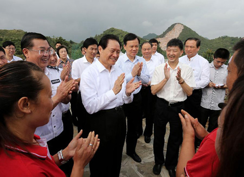 Zhou Yongkang, a member of the Standing Committee of the Political Bureau of the Communist Party of China Central Committee and secretary of the Committee of Political and Legislative Affairs of the CPC Central Committee, chats with rehabilitants who used