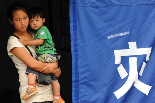 A mother and her child in a tent at a relocation site in Yiliang,Yunnan province, on Tuesday.WEI XIAOHAO / CHINA DAILY