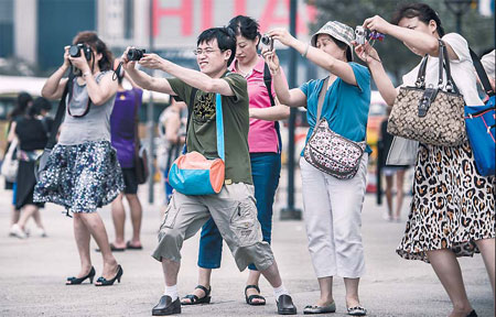 Tourists from the Chinese mainland take pictures during a visit to Hong Kong on Aug 28. Philippe Lopez / AFP