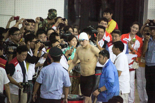 Sun Yang walks past a crowd of media and fans after winning a gold medal at the 200m freestyle at the 9th University Games of China in Tianjin, on Sept 12. [Photo/Xinhua] 