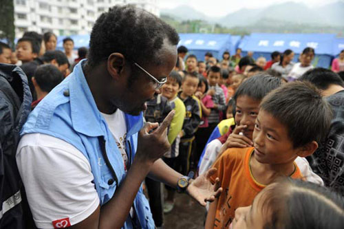 Diarra Boubacar, a 48-year-old volunteer from Mali, talks to children on Wednesday at the Xinchang Middle School in Yiliang county, Yunnan province. Wei Xiaohao / China Daily