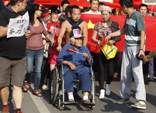 Residents protest against the Japanese government's purchase of China's Diaoyu Islands in front of the Japanese embassy in Beijing on Sunday. Zhu Xingxin / China Daily