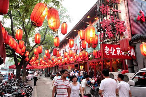 Pedestrains on Guijie Street, the well-known food street in downtown Beijing with many Chinese restaurants side by side. One effective way to expand and develop Chinese restaurants is to learn from the experience of Western restaurant chains and to standa