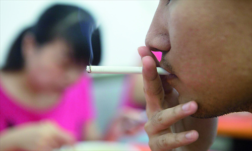 A man smokes while other patrons dine at a small restaurant in Jintai Lu, Chaoyang district, Thursday. Photo: Guo Yingguang/GT 