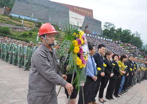 People place a wreath to mourn for those killed in deadly earthquakes earlier this month in Yiliang county in Southwest China's Yunnan province on Sept 20, 2012. [Photo/Asianewsphoto] 