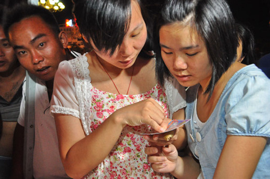 Two women studying a lottery ticket in Suiyuan county, in East China's Jiangxi province. According to a recent online survey conducted by China Lottery Industry Salon, more than half of the people who bought lottery tickets online come from cities while r