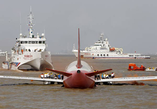 Passengers wait to be rescued on the wings of a plane during an emergency drill, China's first search and rescue exercise involving a civil aircraft, on the Yangtze River estuary in Shanghai on Wednesday. (Photo: China Daily)