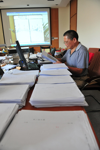 Han Jiegen, history scholar and senior editor of The Collection of Historical Documents on the Ryukyu Kingdom, shows the documents that once again prove China's sovereignty over the Diaoyu Islands, in Shanghai on Wednesday. (Photo: China Daily)