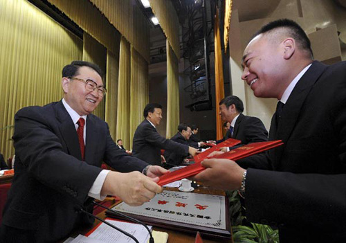 Li Changchun (L), a Standing Committee member of the Political Bureau of the Communist Party of China (CPC) Central Committee, gives a certificate to a representative at an awarding ceremony on the work of reforms and development in the country's cultural