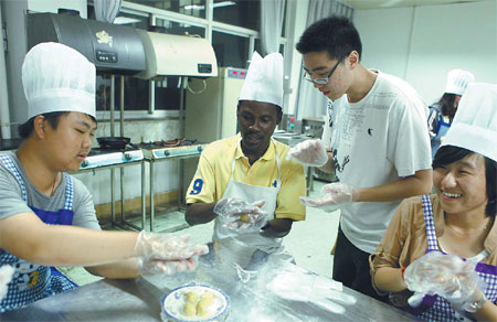 Chinese students teach their classmate from Ghana how to make mooncakes at the Jiangsu University in Zhenjiang, East China's Jiangsu province, on Sept 27. Xu Wei / for China Daily