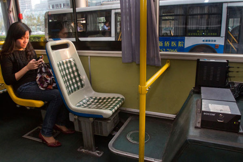 A passenger connects to the free public wireless network on No 82 Bus in Shanghai through her smartphone. [Photo by Yang Shenlai / For China Daily]