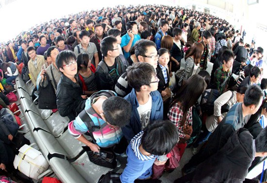 Passengers at the Bozhou Train Station in Anhui province wait in line to check in on Sunday. [Liu Qinli/ For China Daily]