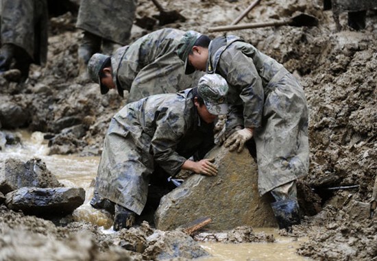 Emergency workers clean up a landslide site in Yiliang county, Yunnan province, on Saturday. Following a series of earthquakes across the county last month, a landslide struck Yiliang on Thursday, killing 19 people including 18 schoolchildren. [Photo/Xinh