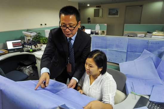 Zhou Mingjue talks with his colleague in Changsha, Central China's Hunan province, Sept 26, 2012. [Photo/Xinhua] 