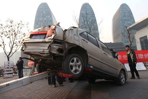 The wreckage of an illicit taxi is put on display on the Beijing North Railway Station's square in December 2011. The vehicle was damaged in a traffic accident. Authorities are reminding residents they should avoid hiring illegal taxis. Provided to China 