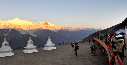 The top half of the Yulong Snow Mountain basks in the sun as visitors use telescopes to view the southernmost snow-capped mountain in the Northern Hemisphere, in Yunnan province on March 12. Lin Yiguang / Xinhua