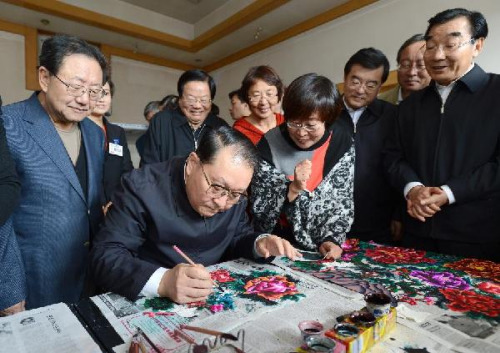 Li Changchun , a member of the Standing Committee of the Political Bureau of the Communist Party of China Central Committee, experiences Chinese paper-cut in Nanzhangzhuang Village in the city of Zhangjiakou, north China's Hebei Province, on Oct. 9, 2012.