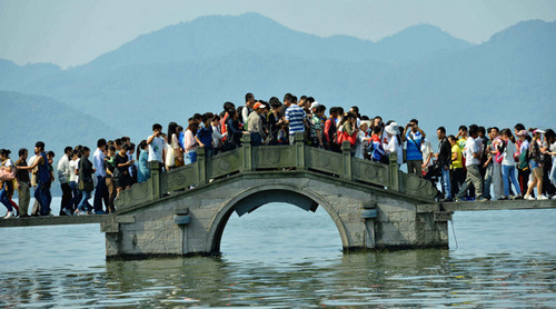 Tourists huddle together on the crowded Yongjin Bridge over West Lake in Hangzhou, the capital of Zhejiang province, on Oct 1 during the National Day holiday. (Long Wei / for China Daily)