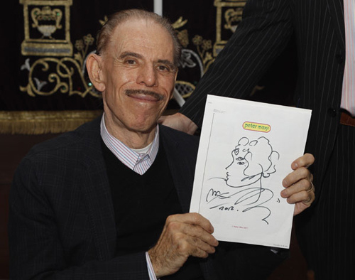 Peter Max, a German-born Jewish American artist, holds a portrait that he painted for his Chinese nanny during his journey in search of her in Shanghai on Thursday. Gao Erqiang / China Daily