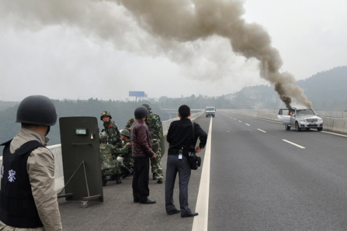 Police inspect the scene of a fatal shooting in which officers killed a suspected drug user on an expressway in Sichuan province on Sunday. They found two handguns at the site.Deng Liang / China News Service 