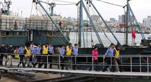 Republic of Korea's coast guards escort Chinese fishermen for investigation upon their arrival on a fishing boat at a port of the coast guard in Mokpo, southwest of Seoul, on Wednesday. ROK coast guard said it was holding 23 Chinese fishermen in custody f