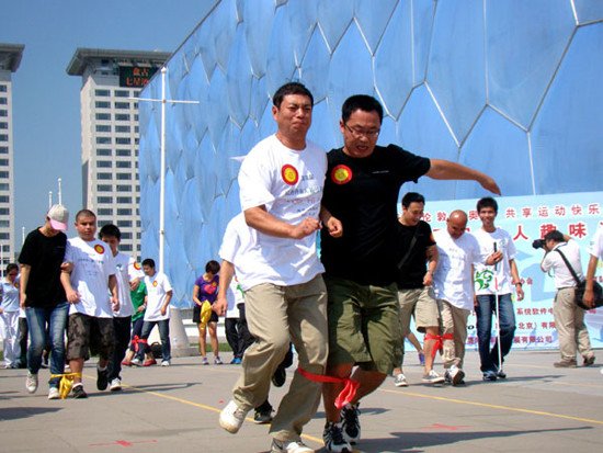 A visually impaired man (left) runs a race, accompanied by a fully sighted volunteer, as part of an event organized for people with visual impairment, at Beijing Olympic Park in the city's Chaoyang district in August. (Photo for China Daily)